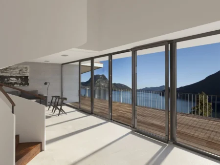 Balconera osciloparalela de PVC en salón con acceso a terraza y vistas al mar