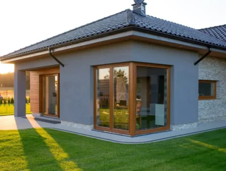 Ventanas de PVC Hermet 10 con acabado madera en vivienda exterior con jardín